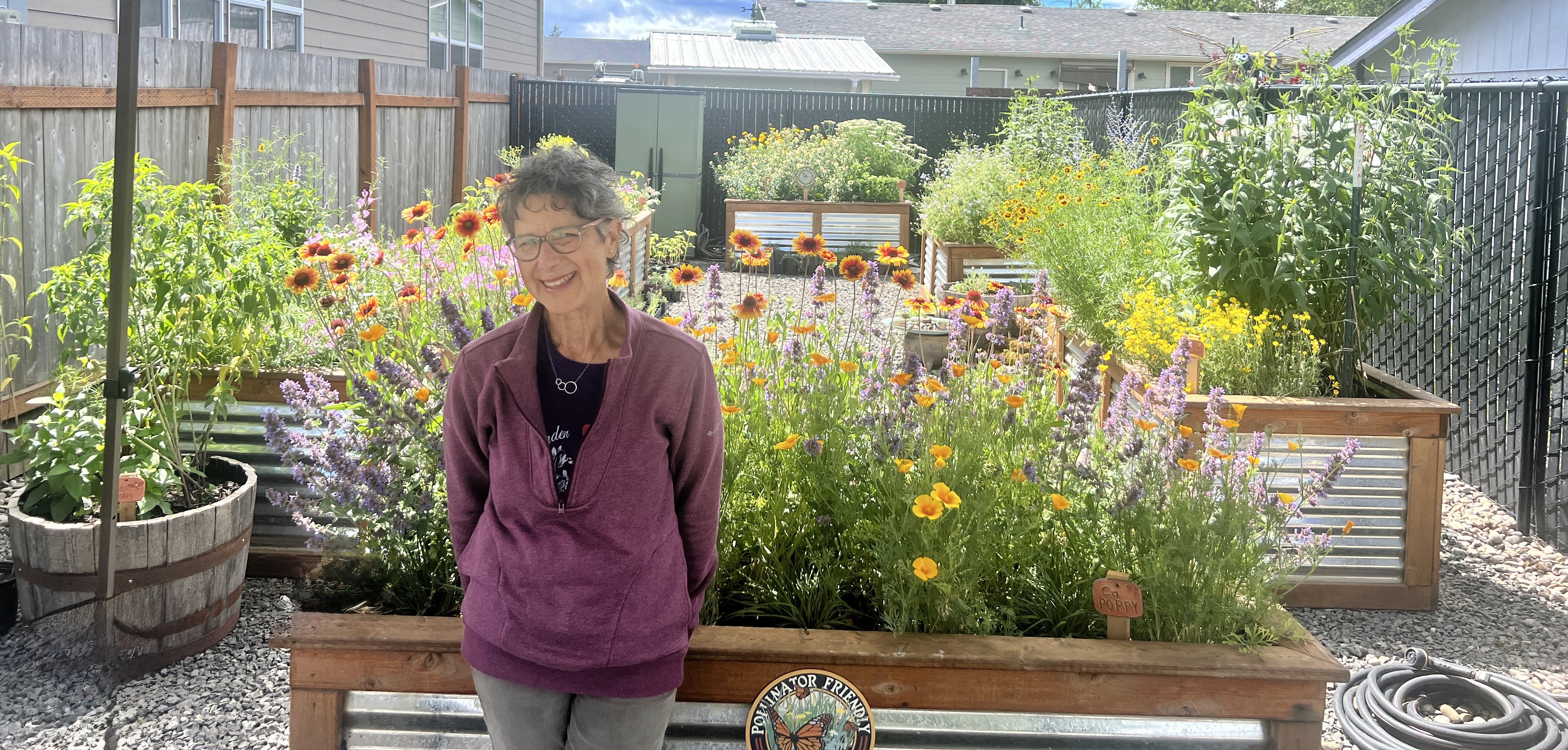 A volunteer standing in the blooming Beetopia pollinator garden