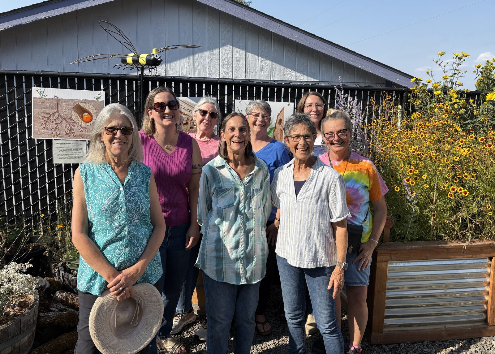 Carlton Pollinator Project volunteers gathered in front of the Beetopia garden beds